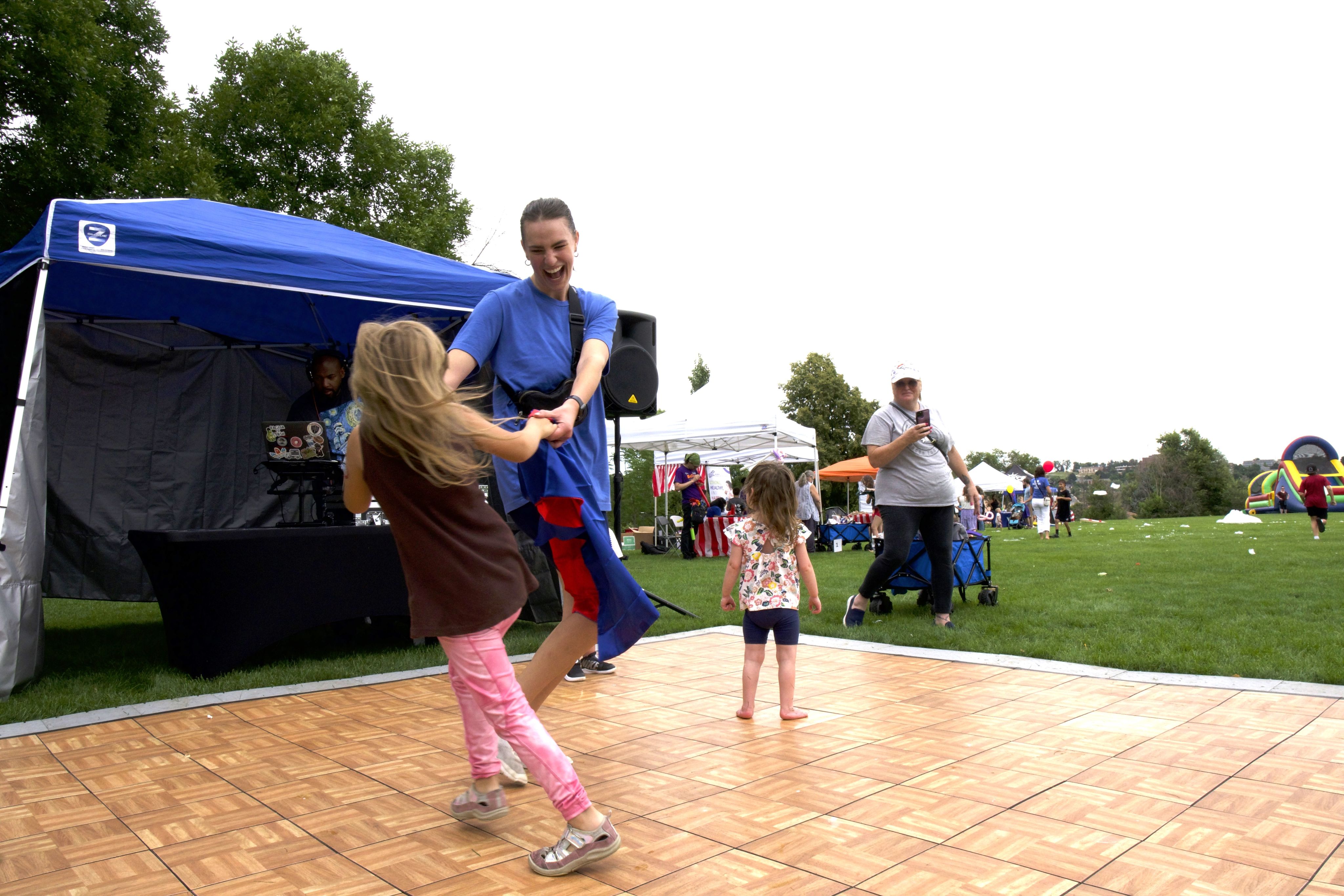 image of mother and daughter dancing at an outdoor festival