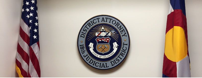 image of the District Attorney emblem between state and County flags