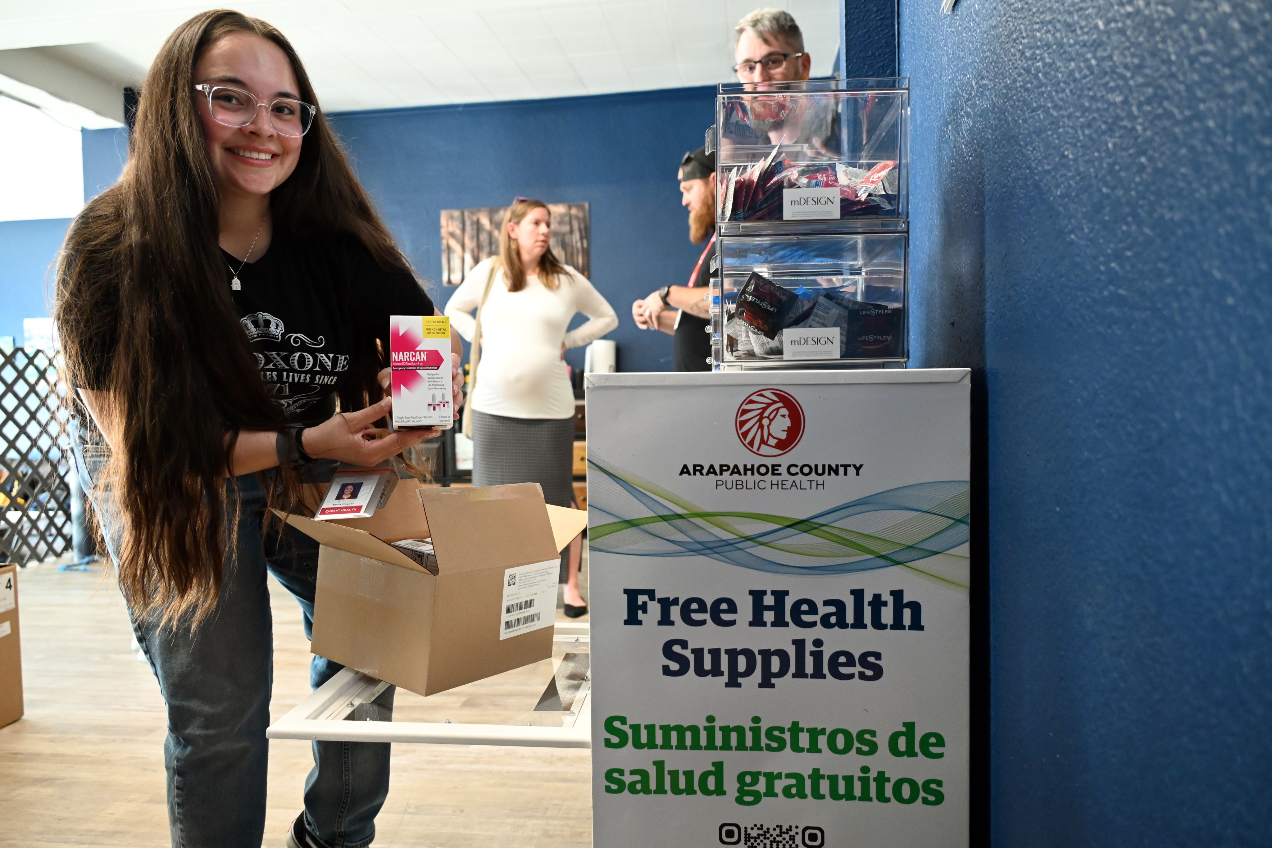 image of an employee putting items in the free health supply kiosk