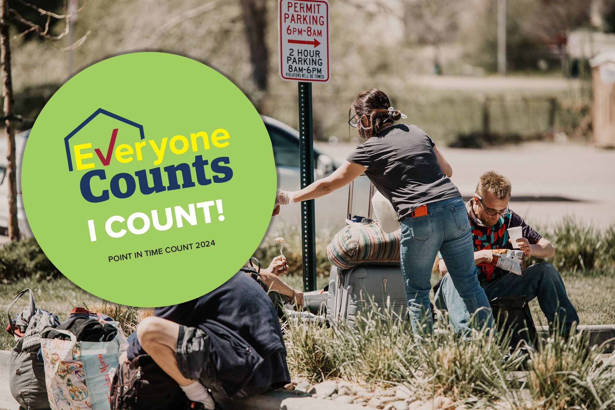 image of a woman handing coffee to some homeless men 